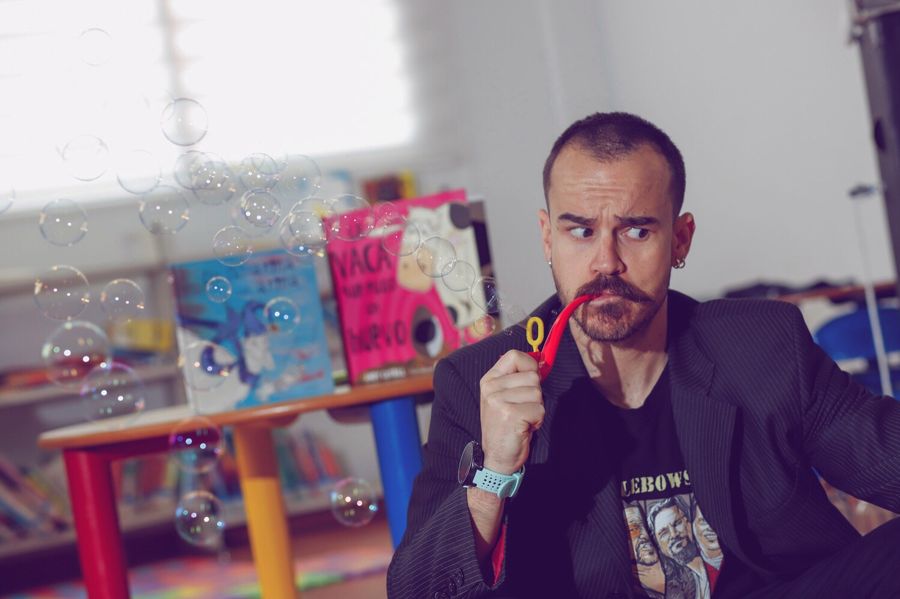 Charlie en una biblioteca entre álbumes ilustrados y pompas de jabón