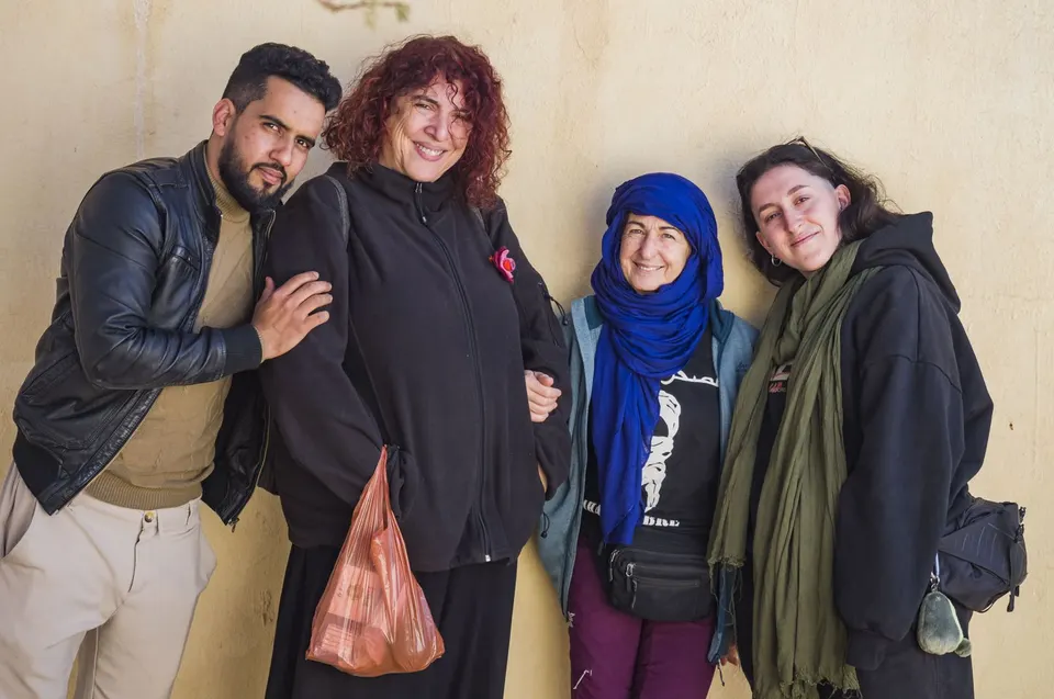 Charlie posa sonriente con tres voluntarias de la expedición contra una pared