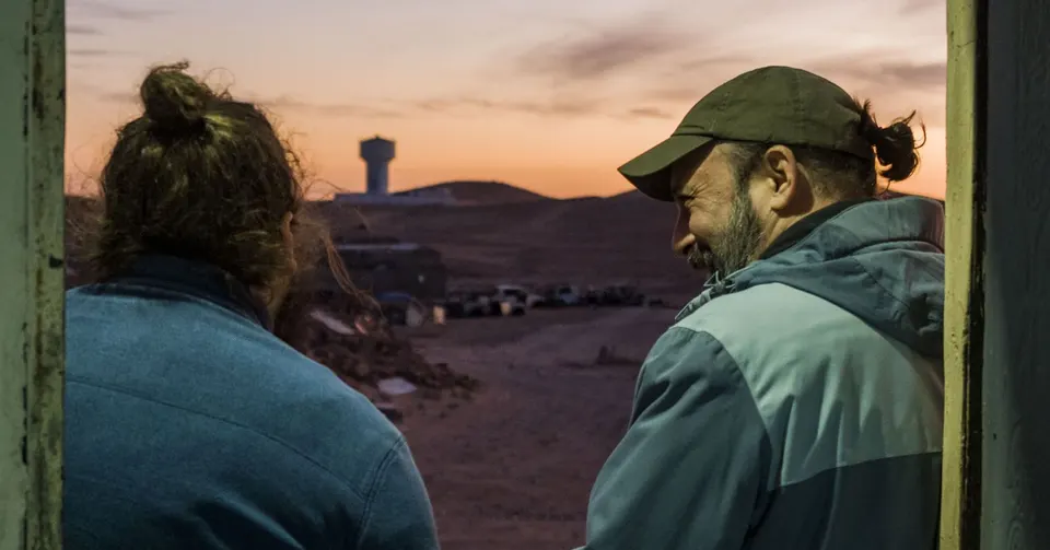 Dos personas del grupo contemplan el atardecer sobre los campamentos